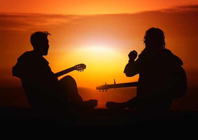 pár s kytarou při západu slunce